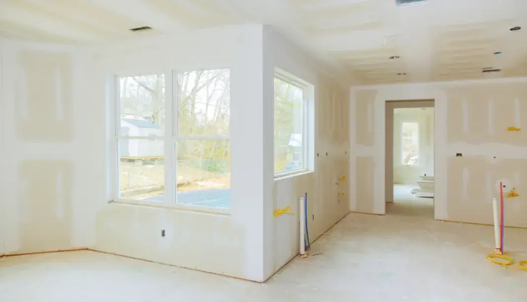 New drywall installation with joint compound applied in a bright interior