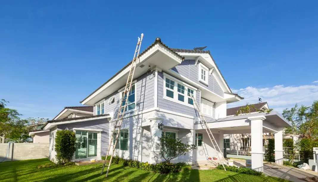 Large modern house with ladders and tools for exterior painting