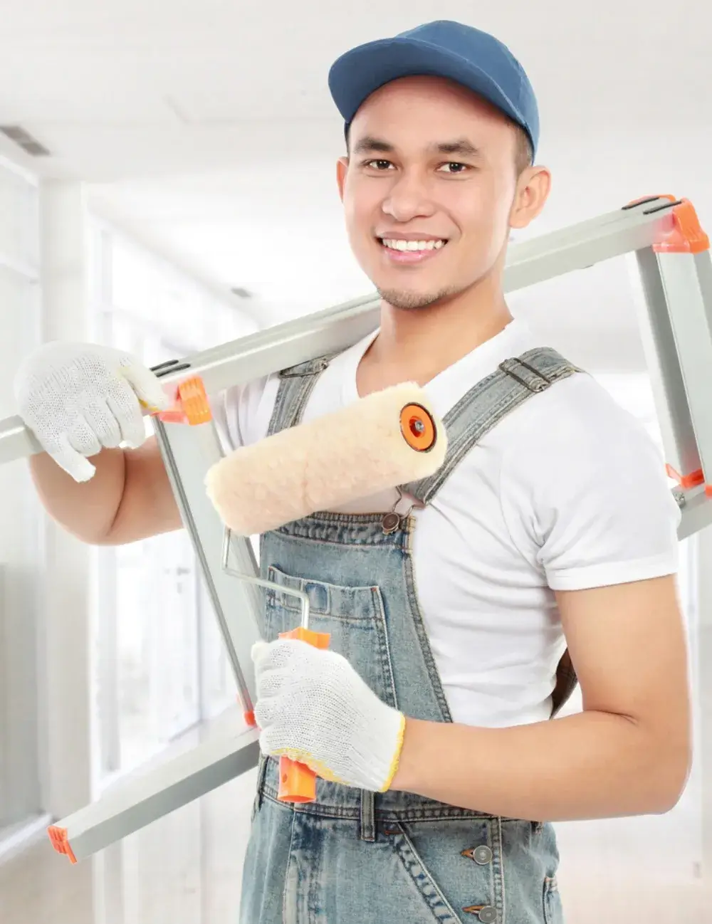 Smiling professional painter holding a ladder and paint roller